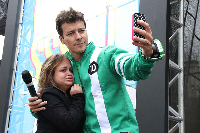 Rodrigo Faro faz selfie com fãs durante a foto.