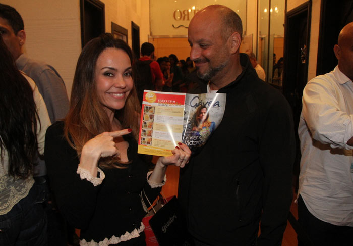 Flávia Monteiro e o marido prestigiam sessão de autógrafos de autor