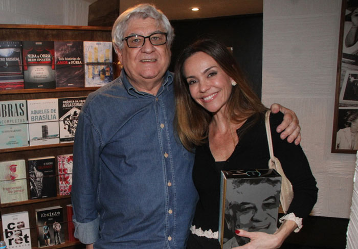 Flávia Monteiro e o marido prestigiam sessão de autógrafos de autor