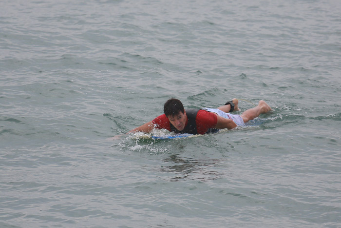 Rodrigo Faro se esforça para tentar pegar onda na praia da Macumba, no Rio 