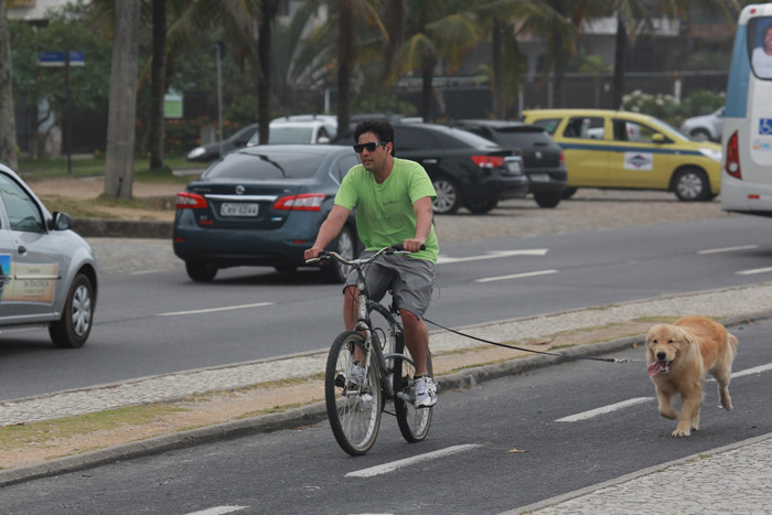 Bruno de Luca pedala enquanto passeia com seu cachorro