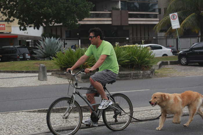 Bruno de Luca pedala enquanto passeia com seu cachorro