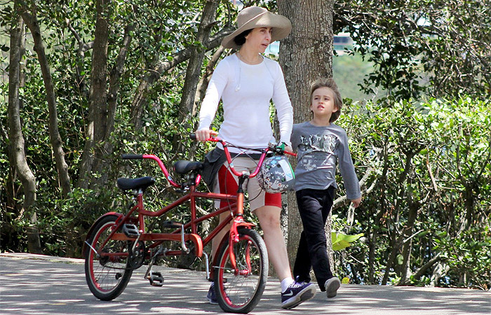 Fernanda Torres usa chapelão para andar de bike com o filho