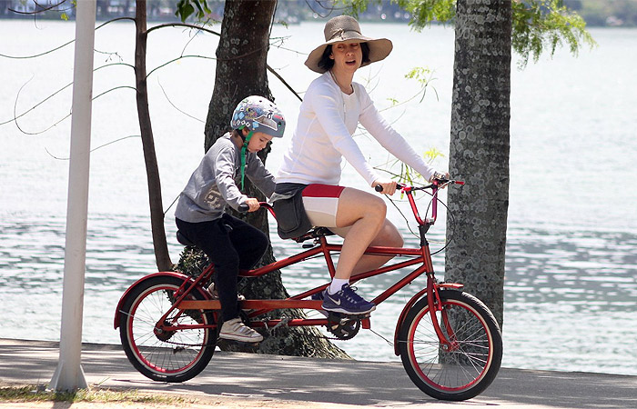 Fernanda Torres usa chapelão para andar de bike com o filho