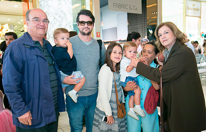 Marcelo Serrado e a esposa levam os filhos à desfile