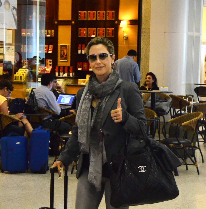 Com bolsa Chanel, Guilhermina Guinle acena para paparazzo em aeroporto