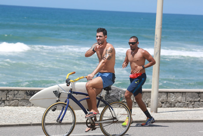 Juliano Cazarré pedala pela orla carioca depois de surfar