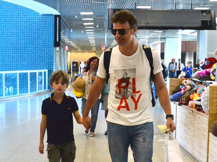 Cassio Reis embarca de mãos dadas com o filho no Rio de Janeiro