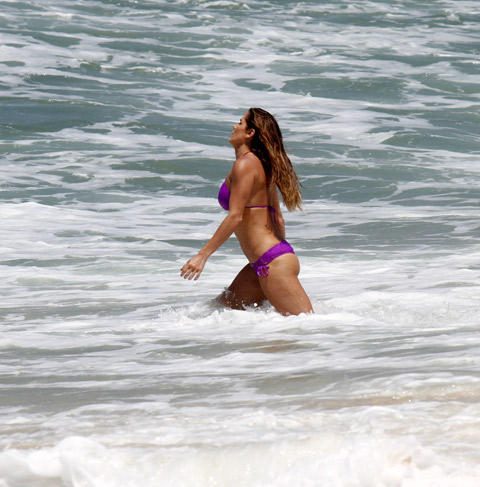 Deborah Secco e Rodrigo Simas desfilam boa forma na praia da Macumba, no Rio