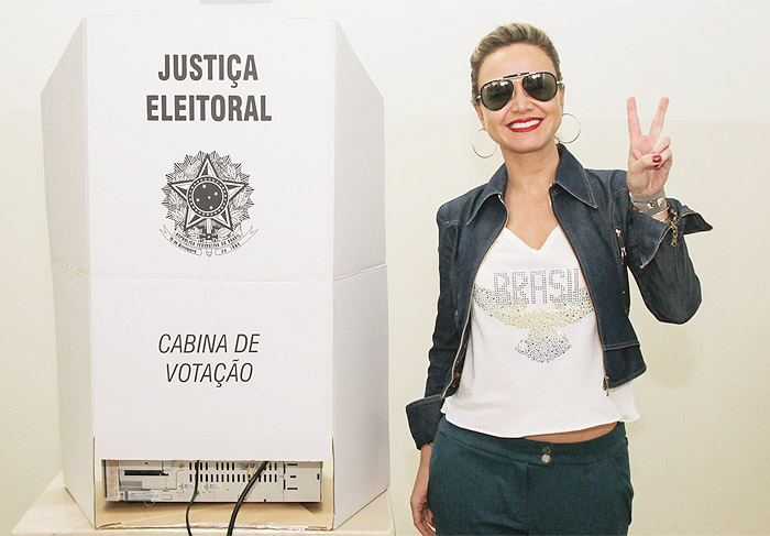 Eliana acena para fotógrafos após votar
