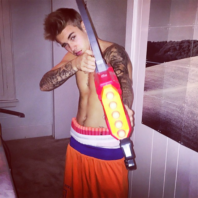 Justin Bieber posa com arma e sem camisa: 'Engatilhada e carregada'