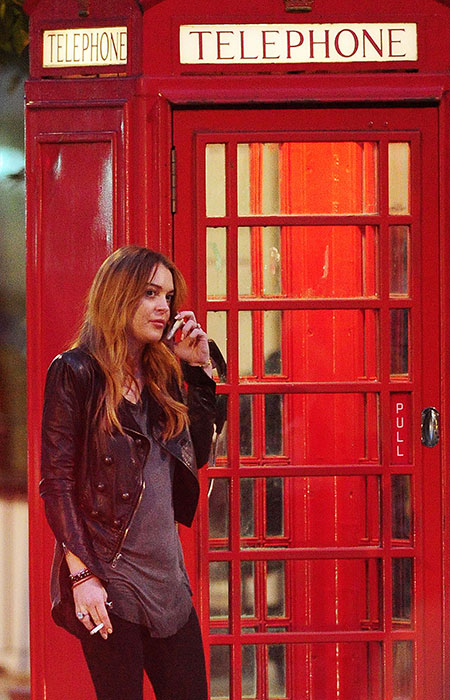 Lindsay Lohan fala ao celular ao lado da famosa cabina telefônica de Londres 