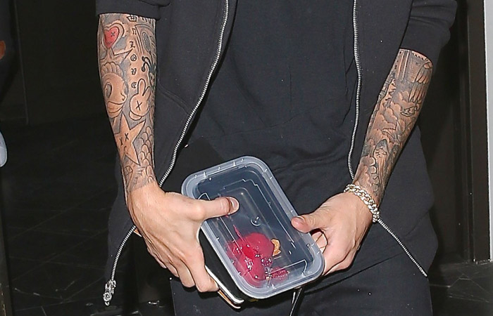 Justin Bieber sai de restaurante com pote de comida em Los Angeles
