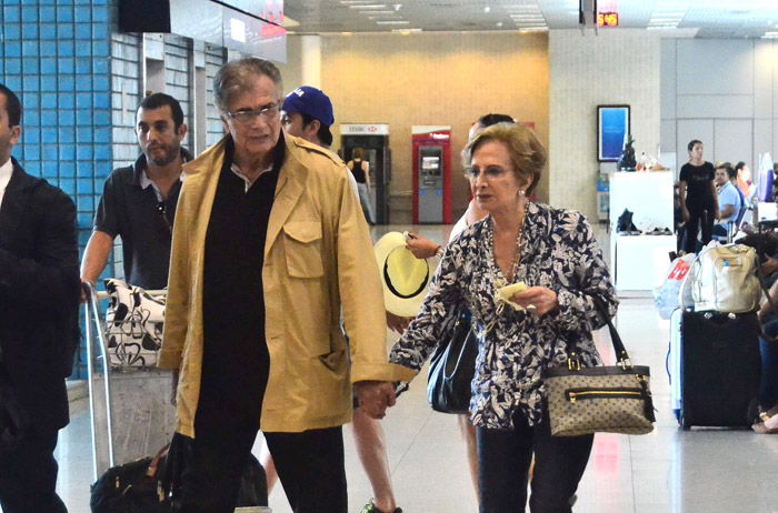 Tarcísio Meira e Glória Menezes andam de mãos dadas em aeroporto 
