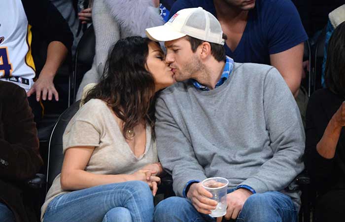 Mila Kunis e Ashton Kutcher trocam beijos em jogo de basquete 