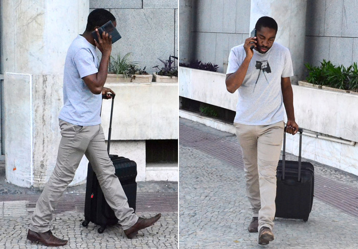 Grudado no celular, Lázaro Ramos chega ao Rio de Janeiro