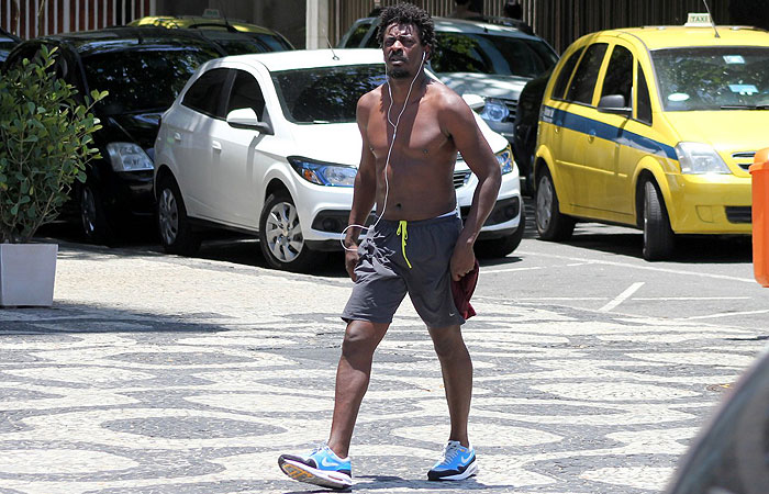 Apesar do calor intenso, seu Jorge corre na orla de Ipanema