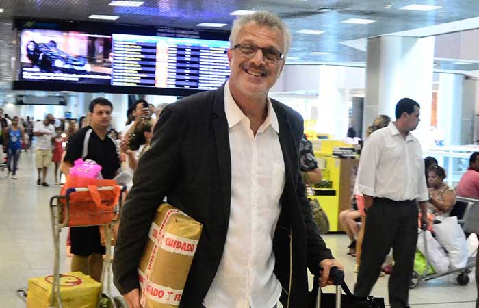 Sorridente, Pedro Bial cumprimenta paparazzo ao deixar o Rio de Janeiro