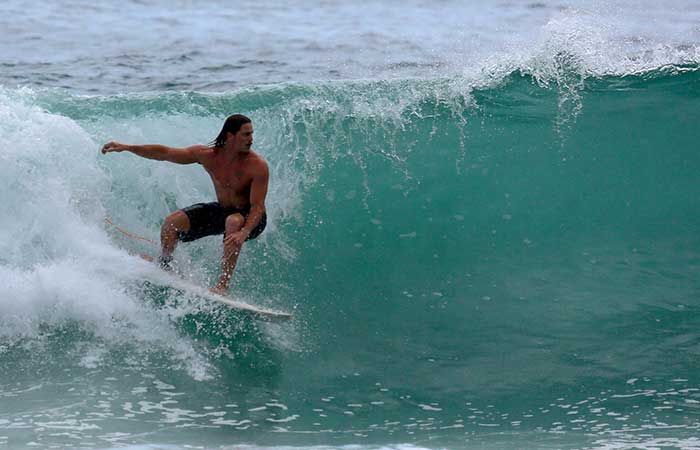 Rômulo Neto aproveita intervalo nas gravações para surfar em praia de São Conrado