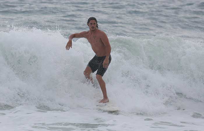 Rômulo Neto aproveita intervalo nas gravações para surfar em praia de São Conrado