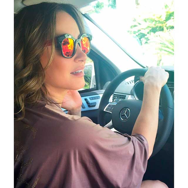 Claudia Leitte faz charme com óculos escuros diferentes em foto dentro do carro