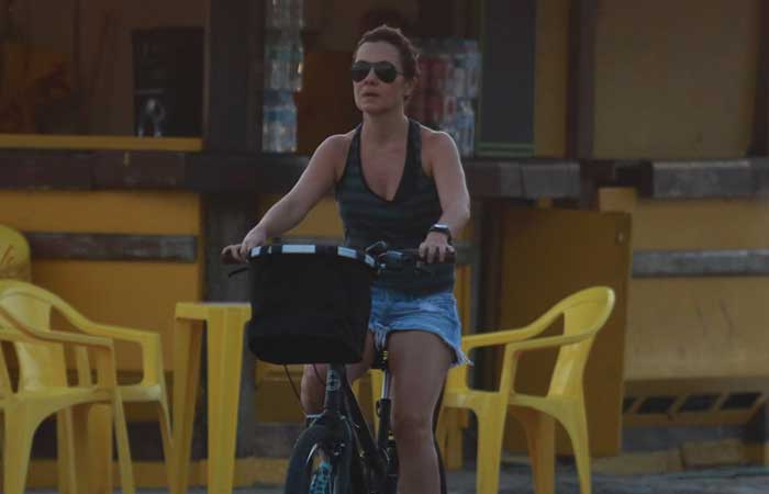 Sem maquiagem e de shortinho, Adriana Esteves pedala na orla da praia da Barra da Tijuca