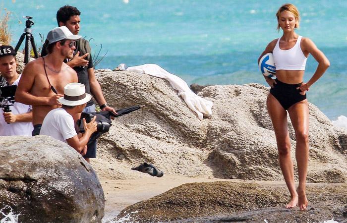 Candice Swanepoel quase mostra demais ao trocar de roupa na praia