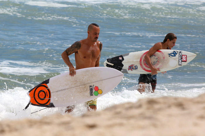 Paulo Vilhena se refresca do calor surfando no mar carioca