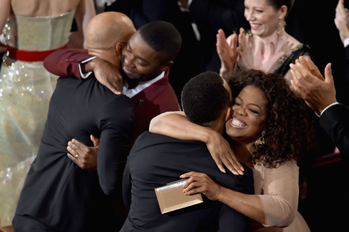 Glory recebe a estatueta de Melhor Canção, por Selma. Na foto, Oprah Winfrey comemora com o elenco e cantor John Legend