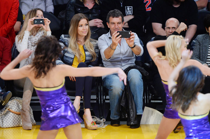 Antonio Banderas se diverte com a namorada em jogo de basquete