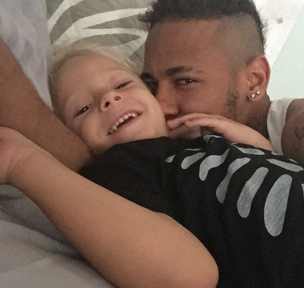 No Brasil, Neymar se diverte com o filho ainda na cama