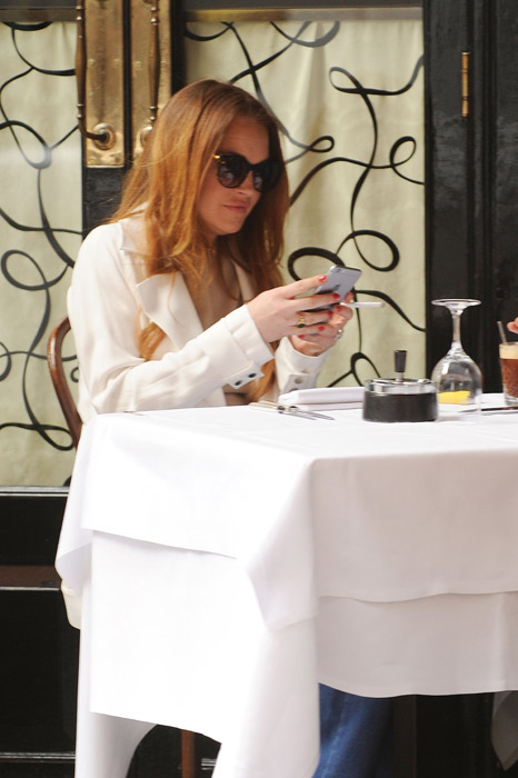 Lindsay Lohan não desgruda do celular durante almoço