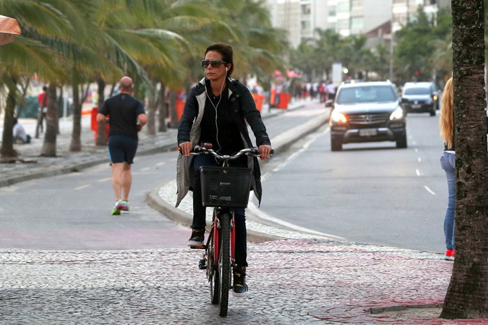 Com look todo preto, Andréa Beltrão passeia de bicicleta pela orla de Ipanema