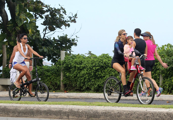 Bem acompanhada, Grazi Massafera passeia de bicicleta pela orla carioca