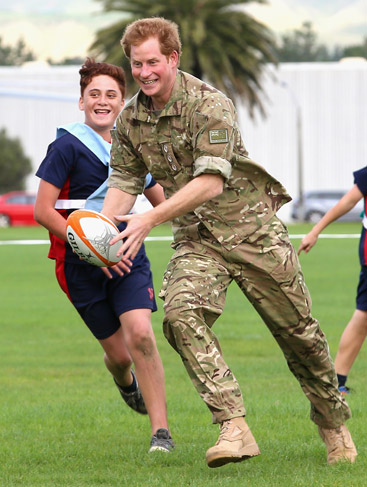  Príncipe Harry se diverte jogando rugby com crianças em visita à base militar na Nova Zelândia