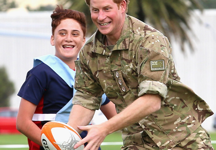  Príncipe Harry se diverte jogando rugby com crianças em visita à base militar na Nova Zelândia