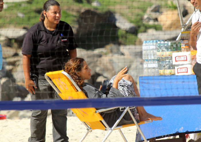Camila Pitanga mexe no celular durante  gravação na praia