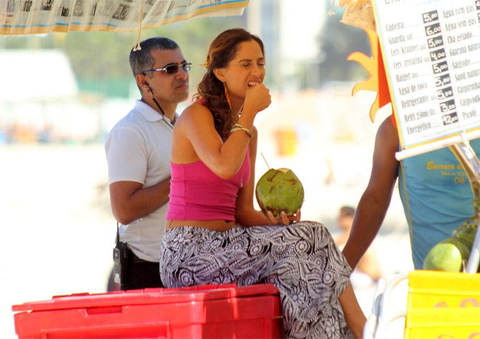 Camila Pitanga bebe água de coco durante gravação