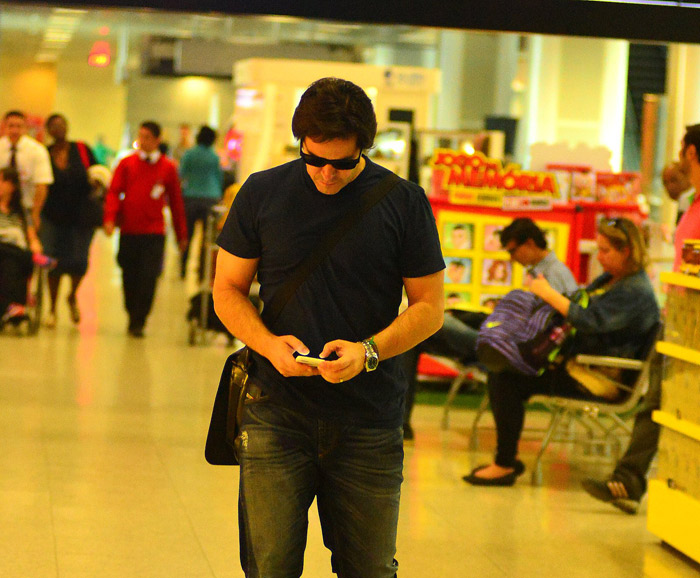 Fiuk faz pose ao encontrar fotógrafos no aeroporto