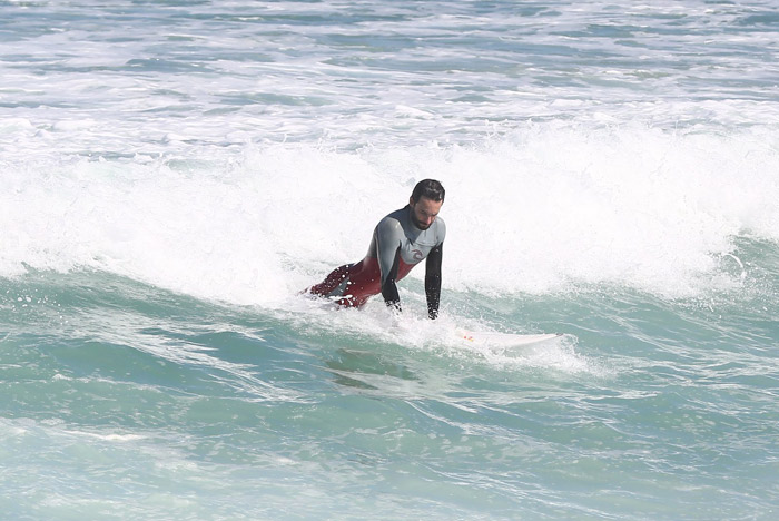 Rodrigo Santoro relaxa ao surfar na praia da Macumba, no Rio
