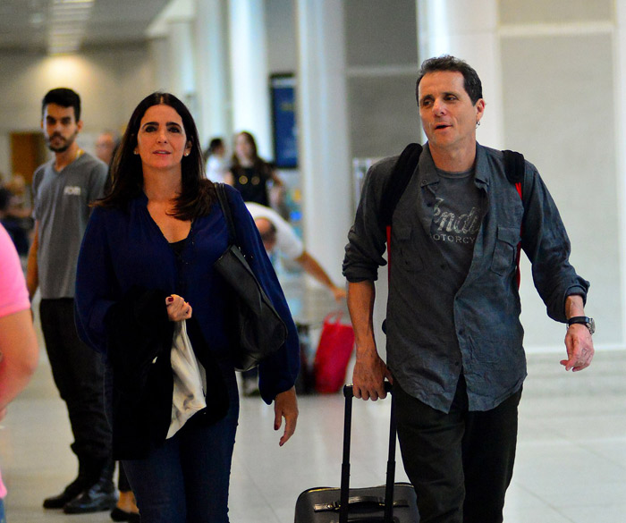 Malu Mader embarca sorridente com o marido em aeroporto