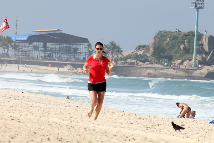 Glenda Kozlowski corre na areia carioca e tira foto com fã