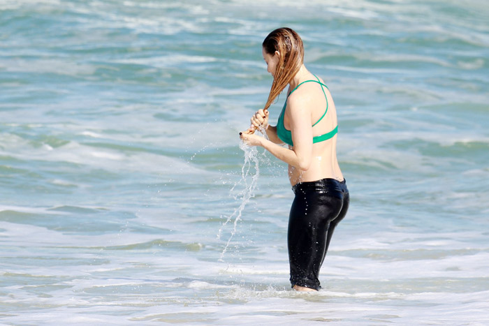 Rita Guedes entra no mar com roupas de ginástica