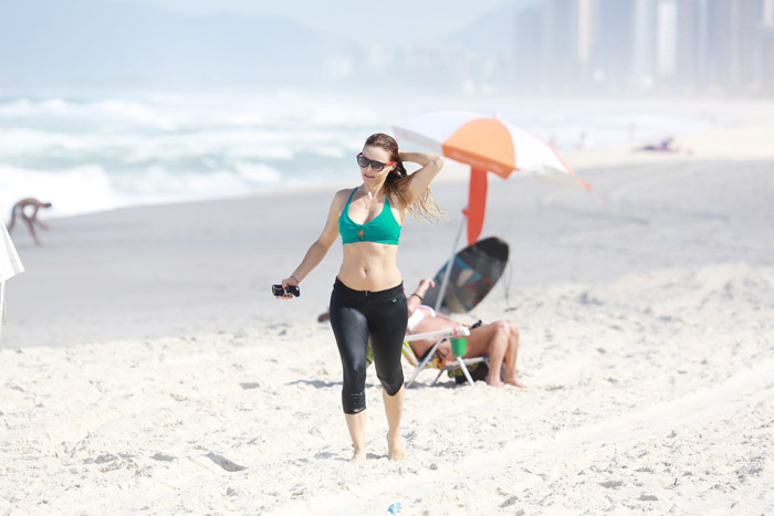 Rita Guedes entra no mar com roupas de ginástica