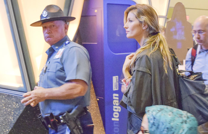 Gisele Bündchen é escoltada por policial em aeroporto