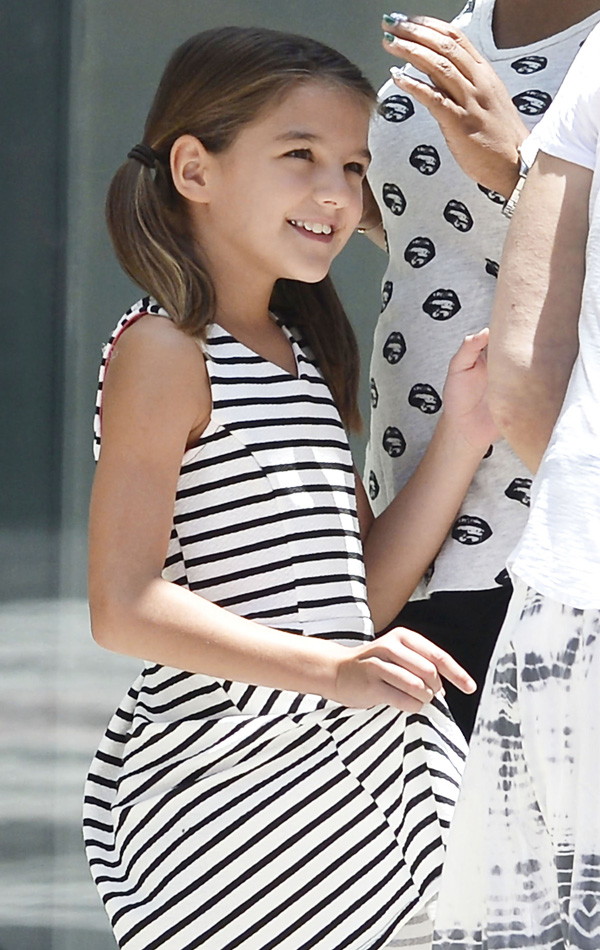 Suri Cruise passeia sorridente com a babá