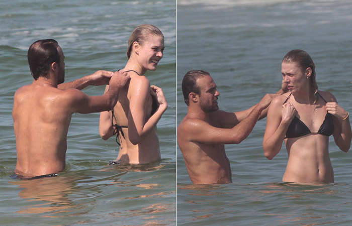 Na praia, Roger Flores dá uma mãozinha para namorada