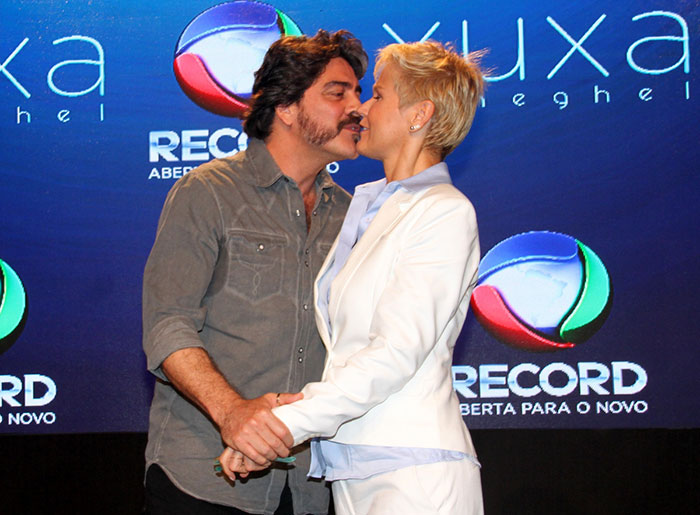 Xuxa realizou coletiva de imprensa, nesta terça-feira (11), para falar de seu novo programa na Record. Nos bastidores, a apresentadora ganhou beijinhos do namorado, Junno Andrade