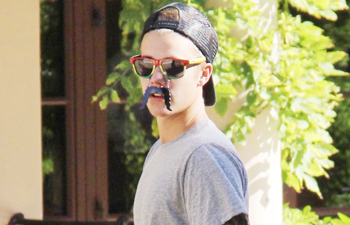Justin Bieber joga futebol com bigode e óculos escuros