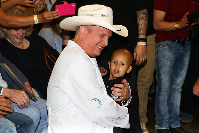 Garth Brooks posa com criança do Hospital de Câncer de Barretos